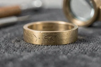 Gros plan sur le poinçon d'un anneau en or vintage posé sur velours gris, montrant la marque de garantie gravée en détail